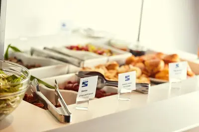 a buffet of food with signs on a counter at Hotel Srbija Garden-FREE PARKING-upon availability in Belgrade