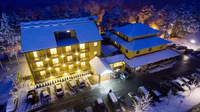 an aerial view of a building with cars parked in a parking lot at Hotel Borkovac in Ruma