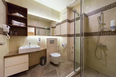 a bathroom with a toilet and a sink and a shower at Hotel Borkovac in Ruma