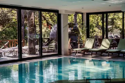 a pool with chairs and tables and windows at Hotel Borkovac in Ruma