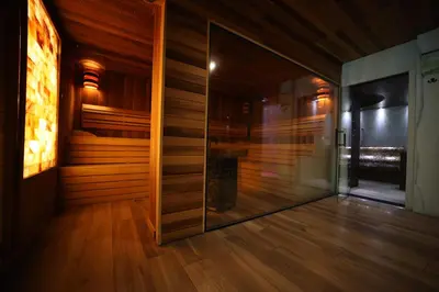 a room with wooden walls and a glass door at Hotel Borkovac in Ruma