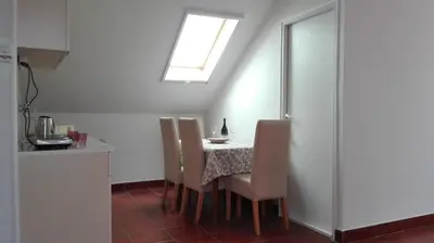 a kitchen with a table with chairs and a window at Apartment Dixy in Belgrade
