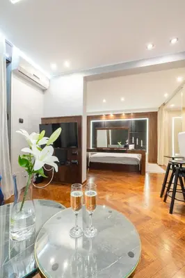 two glasses of wine on a glass table in a room at Onyx luxury apartments in Belgrade