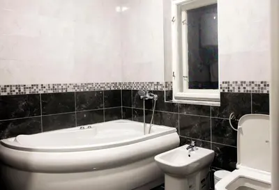 a bathroom with a tub and a toilet and a sink at Natalie's Apartment in Belgrade