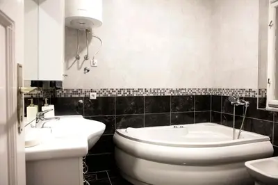 a bathroom with two sinks and a toilet and a tub at Natalie's Apartment in Belgrade