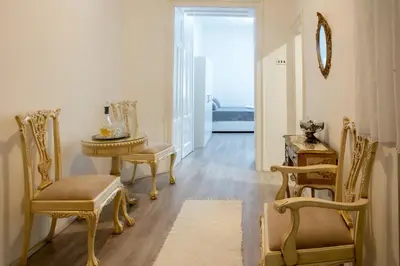 a hallway with a table and chairs and a mirror at Natalie's Apartment in Belgrade