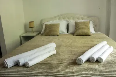 a bed with four pillows on top of it at Natalie's Apartment in Belgrade