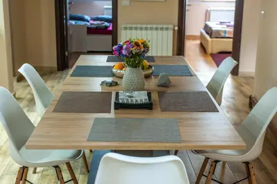 a wooden table with chairs and a vase of flowers at Wizard House Belgrade in Belgrade