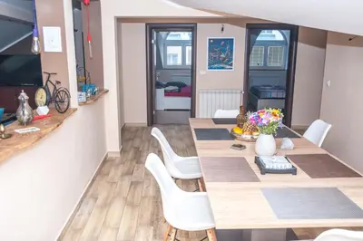a dining room with a table and white chairs at Wizard House Belgrade in Belgrade