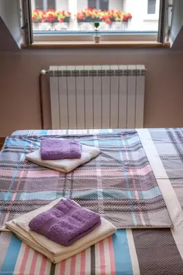 a bed with purple towels on it with a window at Wizard House Belgrade in Belgrade