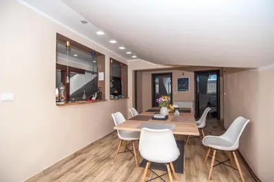 a dining room with a wooden table and white chairs at Wizard House Belgrade in Belgrade