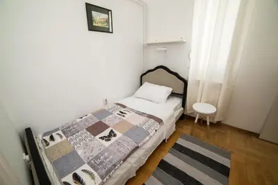 a small bedroom with a bed and a table at Apartment Resavska in Belgrade