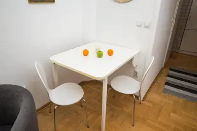 a white table with two oranges and two chairs at Apartment Resavska in Belgrade