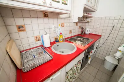 a red counter top in a small kitchen with a sink at Apartment Resavska in Belgrade