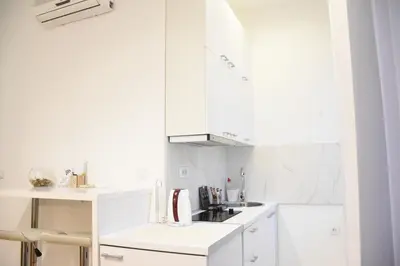 a white kitchen with white cabinets and a sink at Royal park in Belgrade