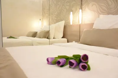 a hotel room with two beds with purple flowers on them at Royal park in Belgrade
