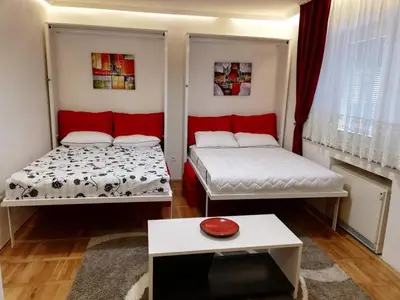 a room with two beds and a table in it at Lola 1 in Belgrade