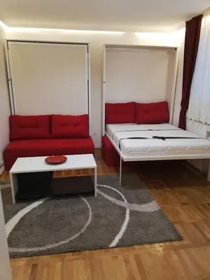 a room with a bed and a red couch at Lola 1 in Belgrade