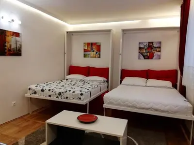 a room with two beds and a table in it at Lola 1 in Belgrade