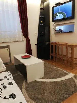 a living room with a white table and a tv at Lola 1 in Belgrade