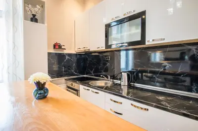a kitchen with white cabinets and a wooden counter top at Belgrade Downtown Residence in Belgrade