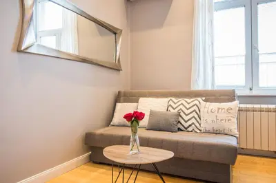 a living room with a couch and a table with a vase of flowers at Belgrade Downtown Residence in Belgrade