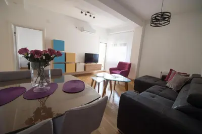 a living room with a table with a vase of flowers at Central Park Lux in Arandjelovac