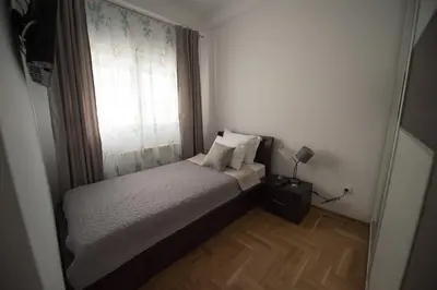 a small bedroom with a bed and a window at Central Park Lux in Arandjelovac