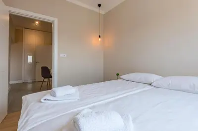 a white bed with two towels on top of it at Urban ZEN with View - City Break Apartments in Belgrade