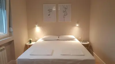 a bedroom with a large white bed with two tables at Urban ZEN with View - City Break Apartments in Belgrade