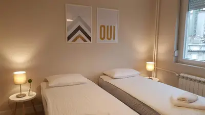 two beds in a room with two lamps and a window at Urban ZEN with View - City Break Apartments in Belgrade