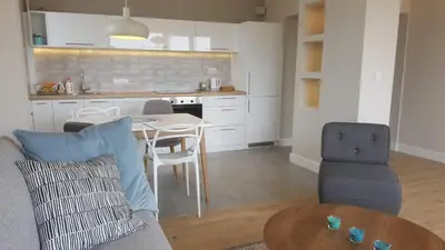 a living room with a couch and a table and a kitchen at Urban ZEN with View - City Break Apartments in Belgrade