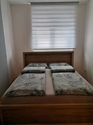a bed in a bedroom with a large window at Apartment Andjela in Belgrade