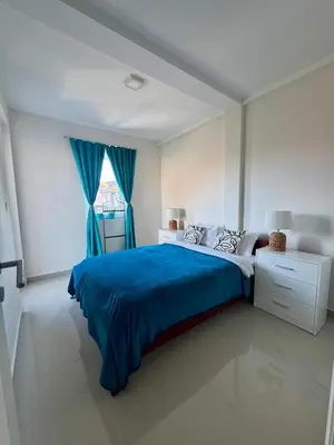 a bedroom with a blue bed and a window at Prenočište Dunav in Novi Banovci