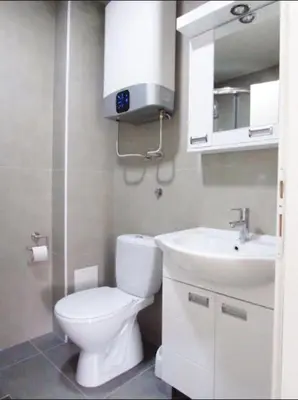 a bathroom with a white toilet and a sink at Prenočište Dunav in Novi Banovci