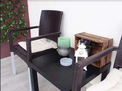 a table with a chair and a green candle on it at Prenočište Dunav in Novi Banovci