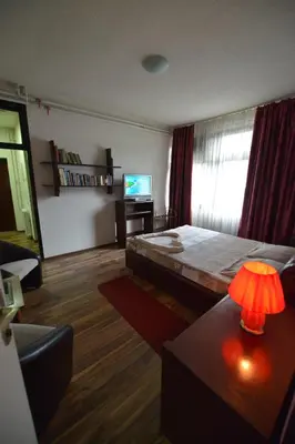a bedroom with a bed and a table and a television at Guesthouse Duga in Belgrade