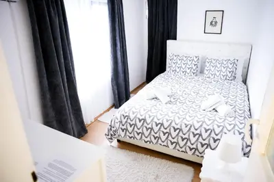 a bedroom with a bed with a black and white comforter at Gardos in Belgrade
