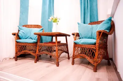 two wicker chairs with blue pillows and a table at Gardos in Belgrade
