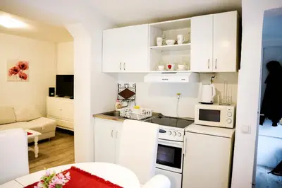 a kitchen with white cabinets and a white stove top oven at Gardos in Belgrade