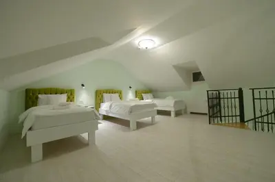 a large room with two beds and a staircase at Srpsko Andrejevo Selo in Belgrade