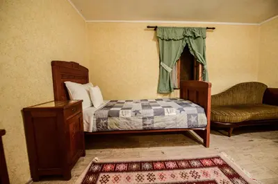 a bedroom with a bed and a chair and a couch at Srpsko Andrejevo Selo in Belgrade
