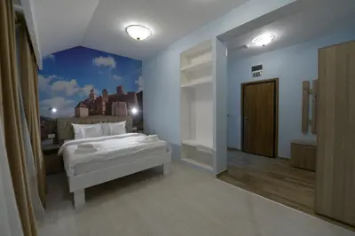 a bedroom with a white bed and a blue wall at Srpsko Andrejevo Selo in Belgrade