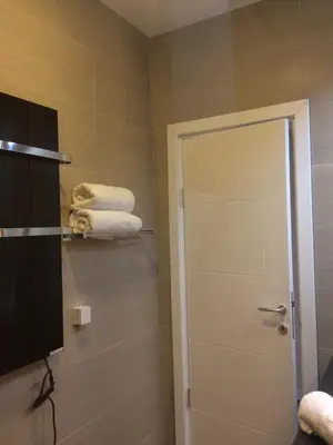 a bathroom with a shower door and some towels at H&M Lux appartment downtown NEW in Belgrade