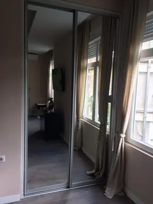 a mirror in a room with two windows at H&M Lux appartment downtown NEW in Belgrade