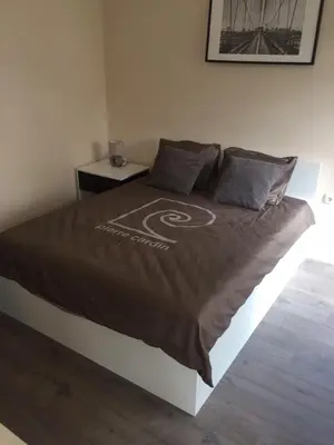 a bed with a brown comforter on it in a room at H&M Lux appartment downtown NEW in Belgrade