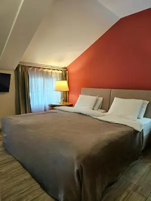 a bedroom with a large bed with a red wall at Male stepenice in Belgrade