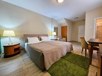 a hotel room with a large bed and a desk at Male stepenice in Belgrade
