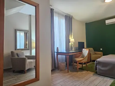a hotel room with a bedroom with a desk and a mirror at Male stepenice in Belgrade