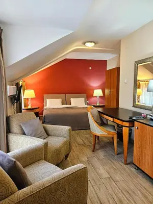 a hotel room with a bed and a table and chairs at Male stepenice in Belgrade